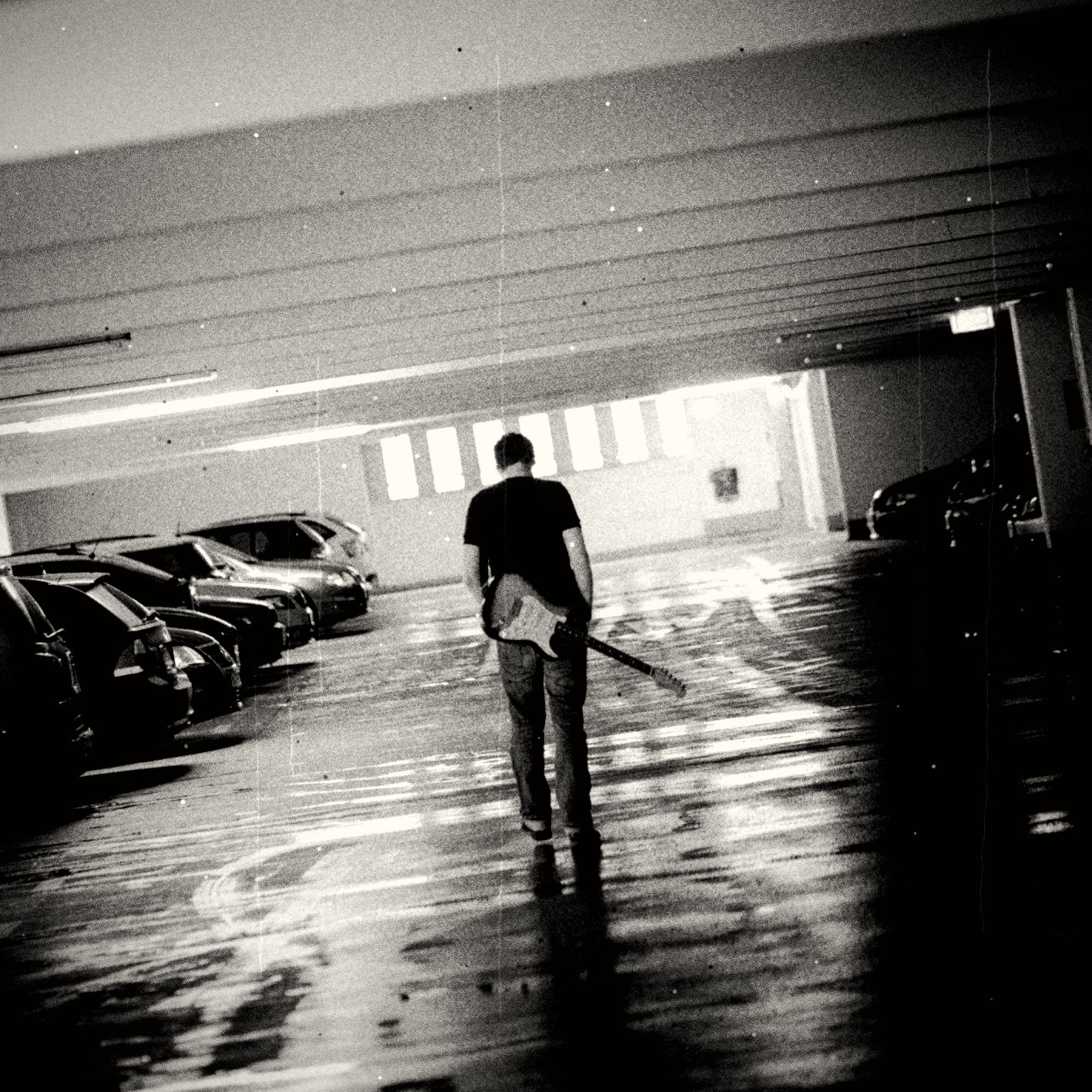 Philipp Schalla walking through a car park with an electric guitar